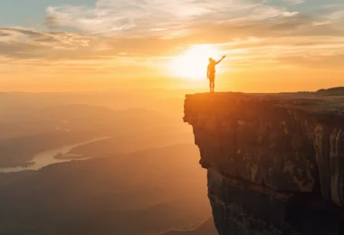 Person standing at edge of cliff symbolizing risk-taking, embracing uncertainty, and personal growth